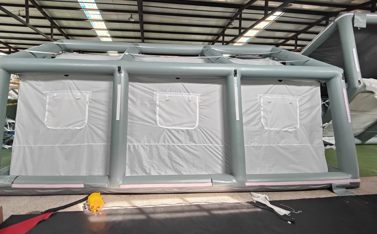 Grey air-beam frame with white wall panels during workshop assembly