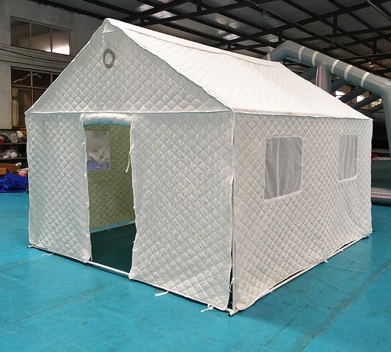White shelter with quilted wall panels, an open doorway and two windows standing on a workshop floor